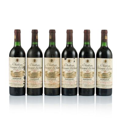 four bottles of wine are lined up on a white surface