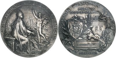 an old silver medal with the image of a woman and a man on it