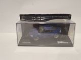 a blue toy car in a clear box on a white surface