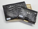 deux portefeuilles en cuir de crocodile noir dans une boîte