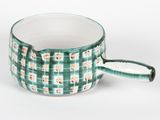 une tasse verte et blanche avec une anse, posée sur une surface blanche