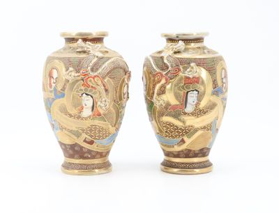 une paire de vases asiatiques posés sur une surface blanche, sur fond blanc