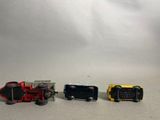 three toy cars sitting next to each other on a white surface