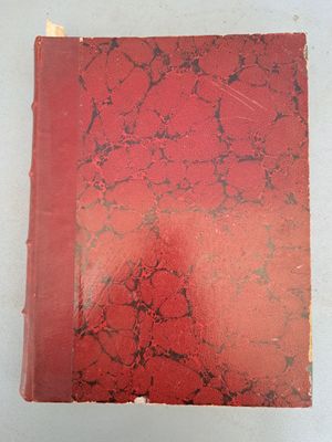un vieux livre à la couverture rouge posé sur une table