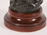 a statue of a man sitting on top of a wooden base
