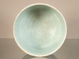 a green bowl sitting on top of a glass table