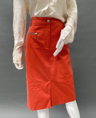 a mannequin wearing an orange skirt and white shirt