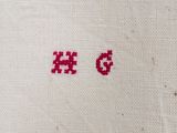 a close up of a piece of cloth with a red cross stitch on it