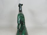 a green statue of a dog sitting on top of a table