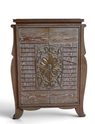 une photo d'un meuble en bois dont la porte est ornée d'un motif sculpté