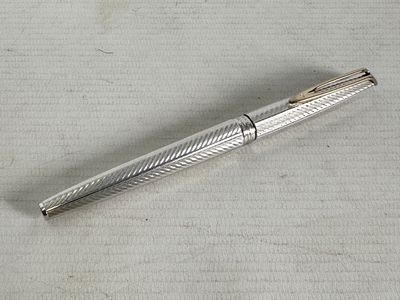 a silver pen sitting on top of a piece of paper