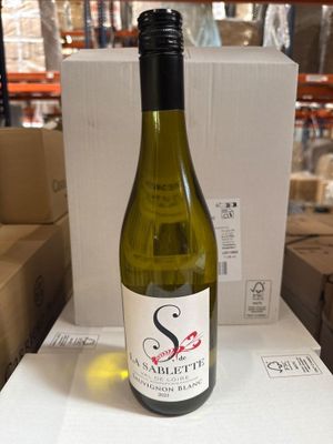 une bouteille de vin posée sur une table dans un entrepôt