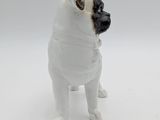 a small figurine of a pug dog on a white surface