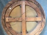 a large wooden wheel with a wooden base on a stand