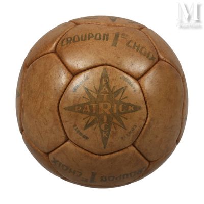 un vieux ballon de foot en cuir marron sur lequel est dessiné un compas