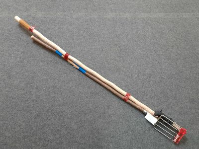 a close up of a fork with a wooden handle on a gray surface
