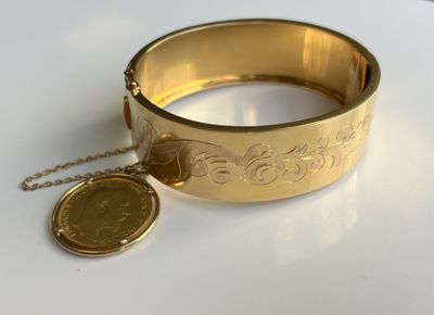 bracelet en or avec une pièce et une chaîne sur un fond blanc