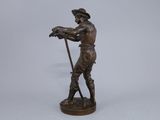 a bronze figurine of a man holding a sheep