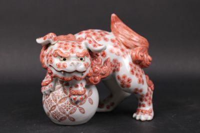 une figurine représentant un chien avec une balle dans la gueule
