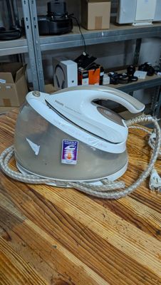 a white steam iron on a wooden table in a room