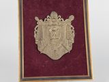 une image représentant une plaque métallique sur laquelle figure un blason