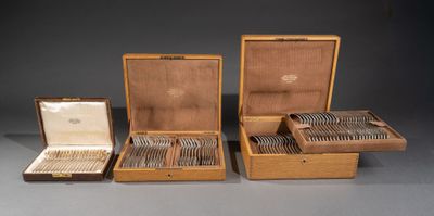 trois boîtes en bois remplies d'argenterie, posées sur une table