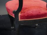 a red chair that is sitting on a black carpet