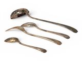 three spoons and a spoon rest on a white surface
