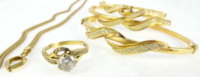 a lot of gold jewelry on a white surface