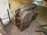 a metal fan sitting on the floor next to a wall