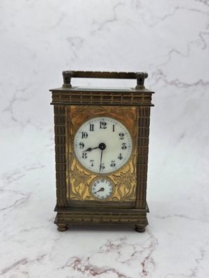 a small clock that is sitting on a marble table