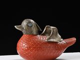a red bird sitting on top of a white box