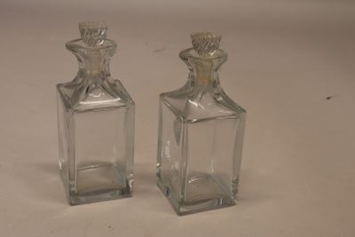 deux petites bouteilles en verre posées sur une table