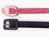 trois ceintures de couleurs différentes, ornées de boucles dorées, sur un fond blanc