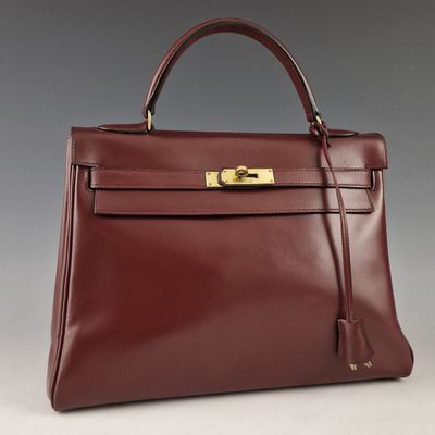 un sac à main en cuir marron avec des ferrures dorées sur la poignée