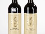 deux bouteilles de vin posées l'une à côté de l'autre sur une surface blanche