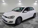 Une Volkswagen Golf blanche est garée sur un sol à damier.