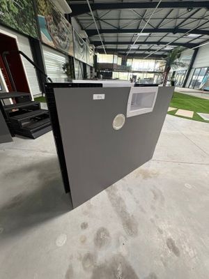 un grand réfrigérateur ouvert, situé dans un bâtiment dont la porte est ouverte