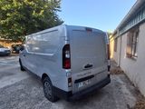 the back of a silver van parked in a parking lot next to a building