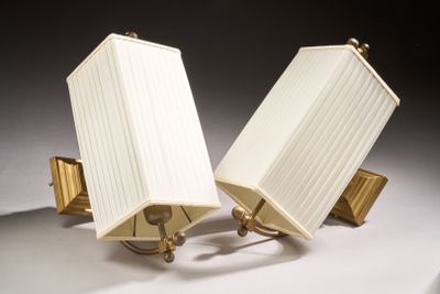 pair of brass table lamps with white lampshads on a white surface