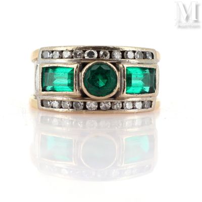 an image of a ring with emeralds and diamonds