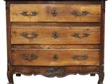 une commode en bois dont les tiroirs sont ornés de sculptures élaborées