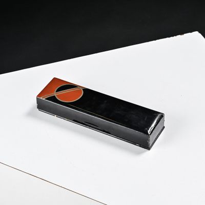 un briquet noir et orange posé sur un morceau de papier