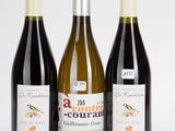 trois bouteilles de vin posées les unes à côté des autres sur une surface blanche