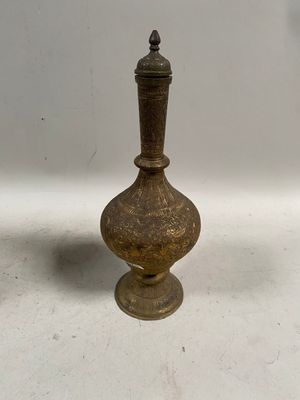 vase plaqué laiton posé sur une surface blanche, sur fond blanc