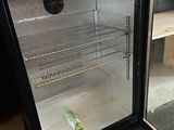 a small refrigerator with a glass door that has a bottle in it
