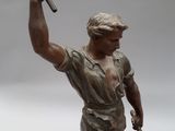 a statue of a man with a hammer in his hand