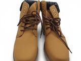une paire de bottes marron avec des lacets marron sur fond blanc