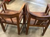 two wooden chairs sitting next to each other on the floor