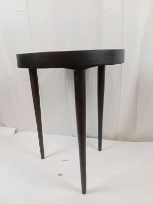 une petite table noire à trois pieds, avec un plateau incurvé